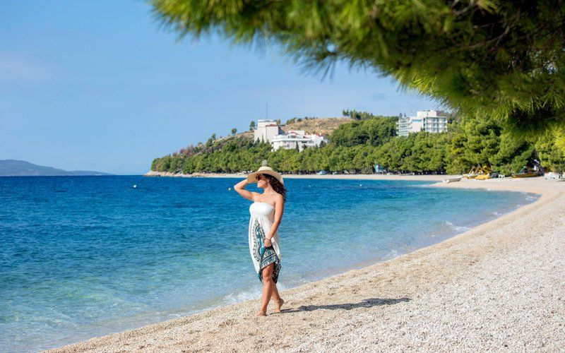 Frau im Sommerkleid am Tucepi Beach, Kroatien