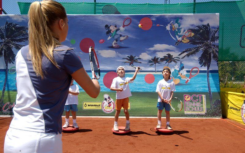 Trainerin mit Kindern vor Trainingszielwand in der Kids Tennis-Funacademy