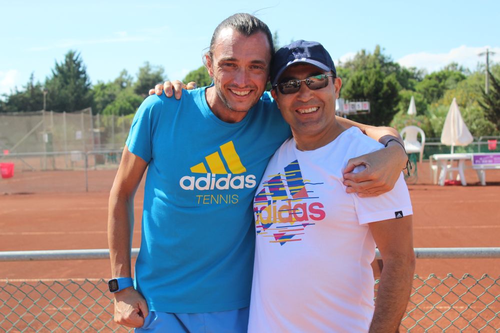 Zwei Männer Arm in Arm auf Tennisplatz