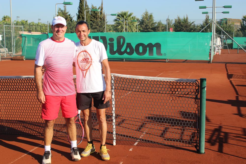 Zwei Männer Arm in Arm auf Tennisplatz