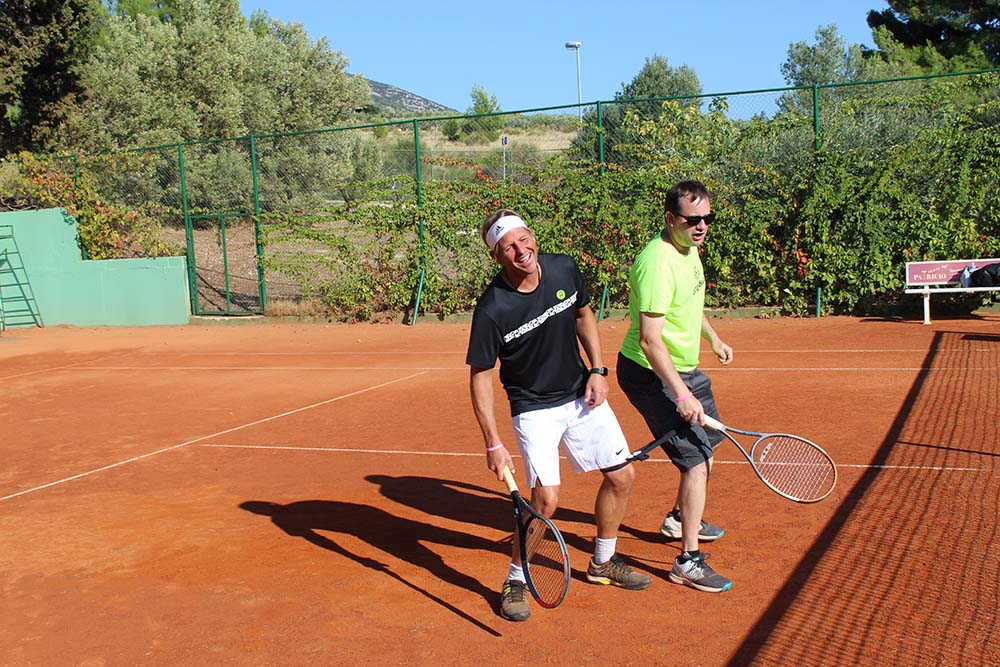 Zwei Tennisspieler lachen auf Tennisplatz
